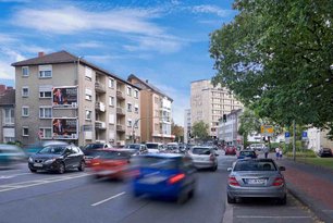 Großflächenplakate an Hauswand an einer stark befahreneren Straße
