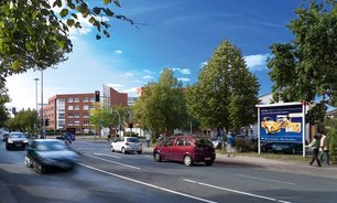 Stadtverkehr an einer mehrspurigen Straße, begleitet von einer Großfläche mit Werbeplakat am Straßenrand.