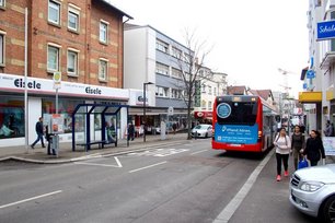 Städtischer Straßenzug mit Bushaltestelle und city light plakat in zentraler Lage. Die Werbefläche erzielt hohe Aufmerksamkeit bei Passanten und öffentlichem Nahverkehr.